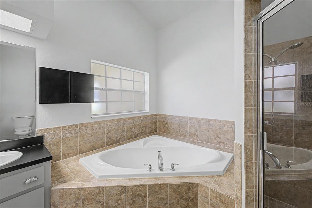15031 Surrey Bend Spring Hill, FL 34609 - Photo 41 of 77 a bath tub sitting in a bathroom next to a sink