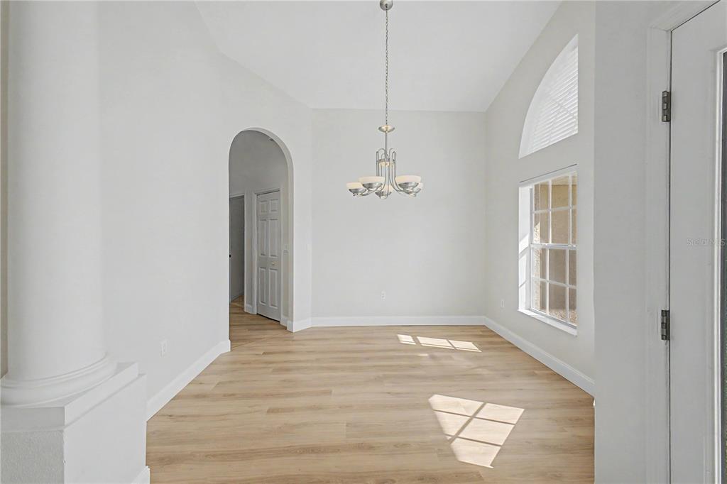 15031 Surrey Bend Spring Hill, FL 34609 - Photo 7 of 77 a view of a room with wooden floor and ceiling fan