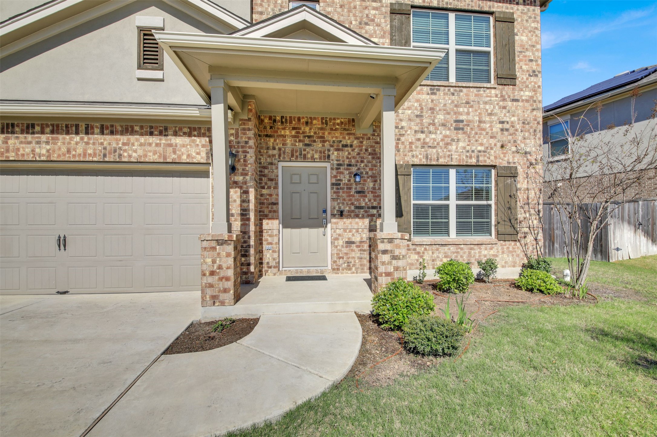 13716 Sugar Bush Path Manor, TX 78653 - Photo 4 of 37 View of exterior entry featuring driveway, brick siding, and an attached garage