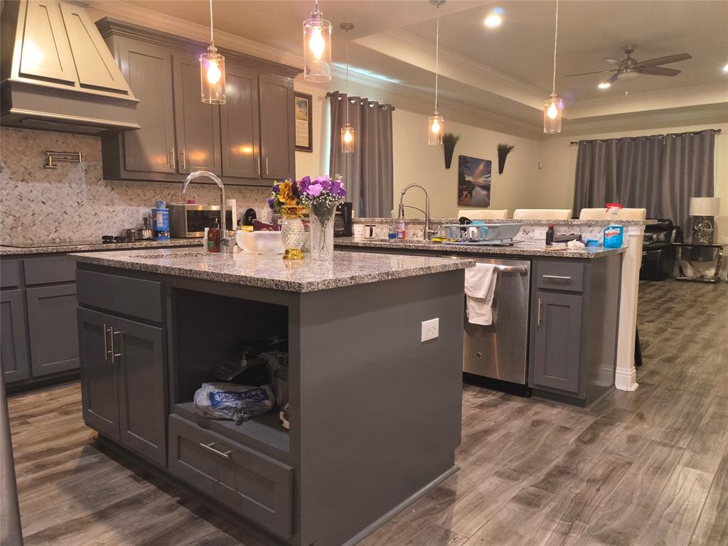 3027 Ames Road Lancaster, TX 75134 - Photo 8 of 35 Kitchen featuring a large island with an undermount sink, granite countertops, and grey cabinetry