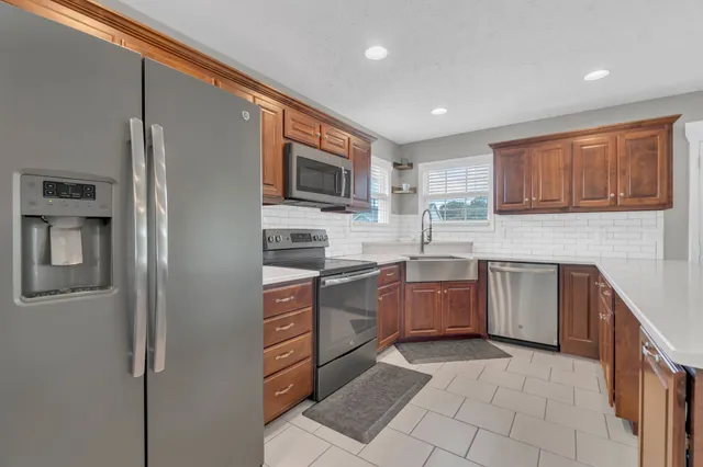 a kitchen with stainless steel appliances granite countertop a refrigerator sink and stove
