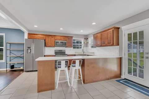 a open kitchen with stainless steel appliances granite countertop a refrigerator and a stove top oven