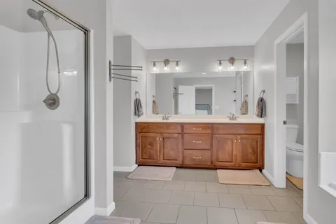 a bathroom with a granite countertop sink a mirror and a shower