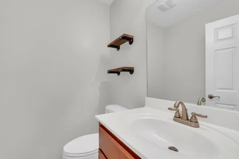 a bathroom with a sink a toilet and a mirror