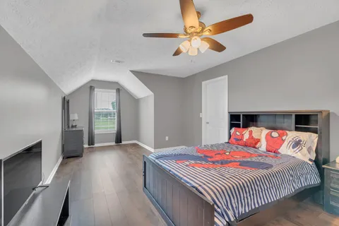 a bedroom with a large bed and a chandelier