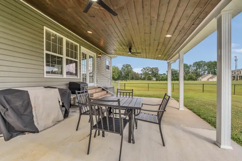 a view of a patio with a table chairs and backyard