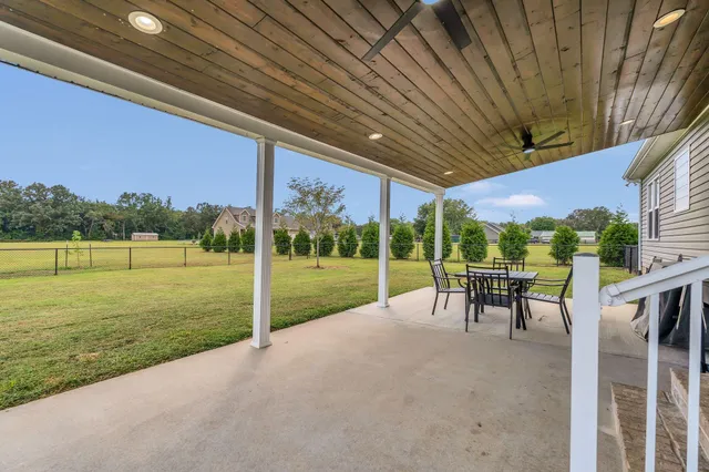 a view of a patio with a table chairs and a backyard
