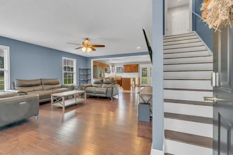 a living room with furniture and a wooden floor