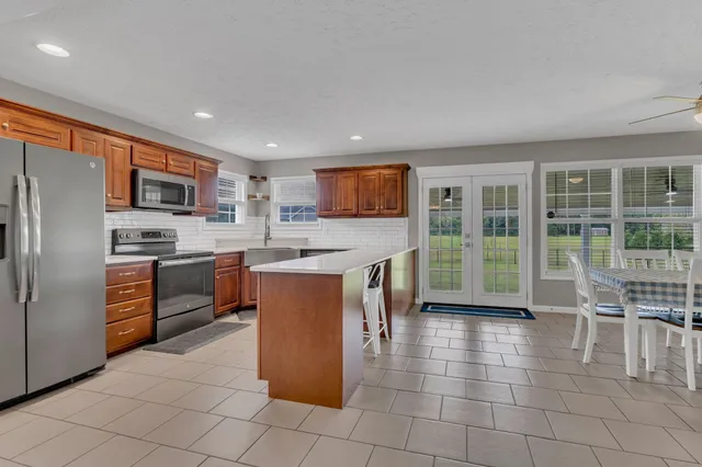 a kitchen with stainless steel appliances granite countertop a stove a sink a microwave and a refrigerator