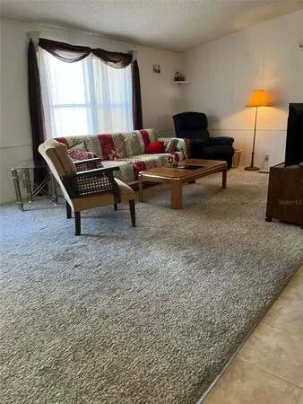 a living room with furniture a rug and a large window