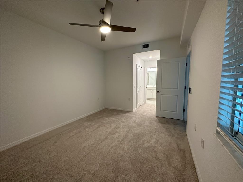 14131 Heritage Landing Boulevard, Unit 822 Punta Gorda, FL 33955 - Photo 12 of 51 an empty room with chandelier fan and windows