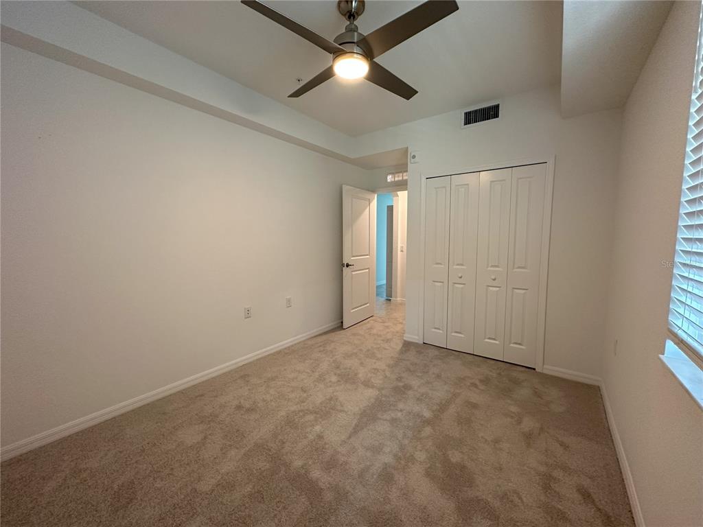 14131 Heritage Landing Boulevard, Unit 822 Punta Gorda, FL 33955 - Photo 18 of 51 an empty room with chandelier fan and windows