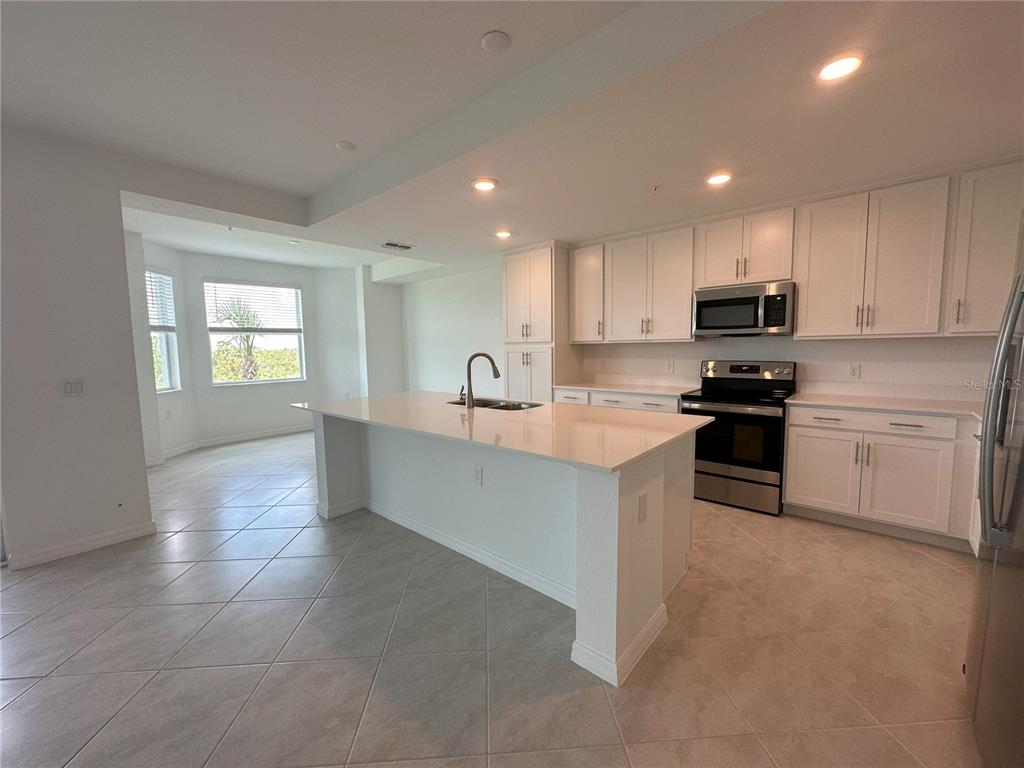 14131 Heritage Landing Boulevard, Unit 822 Punta Gorda, FL 33955 - Photo 3 of 51 a kitchen with granite countertop white cabinets and black stainless steel appliances