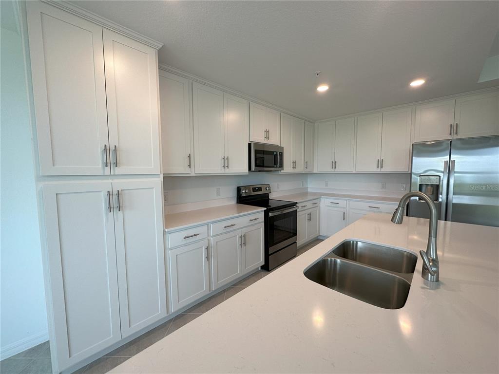 14131 Heritage Landing Boulevard, Unit 822 Punta Gorda, FL 33955 - Photo 4 of 51 a kitchen with granite countertop white cabinets and stainless steel appliances