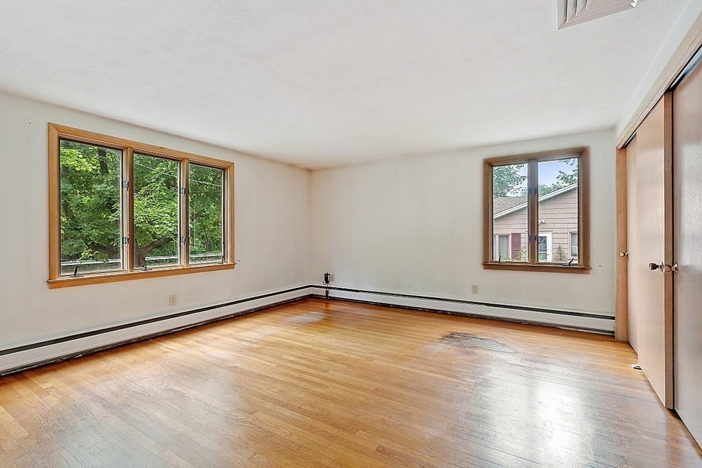 911 Main Street Reading, MA 01867 - Photo 11 of 42 a view of an empty room with wooden floor and a window