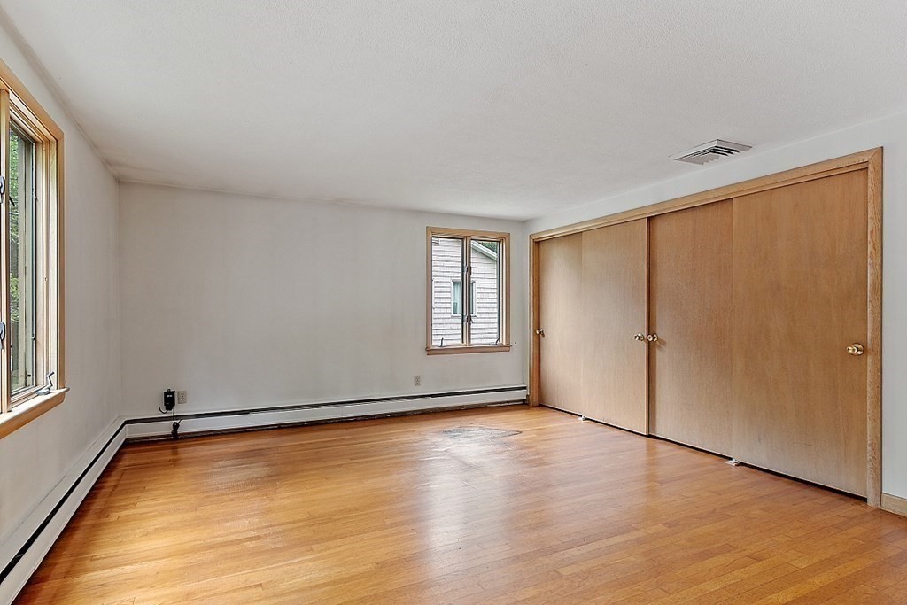 911 Main Street Reading, MA 01867 - Photo 12 of 42 a view of an empty room with wooden floor and a window