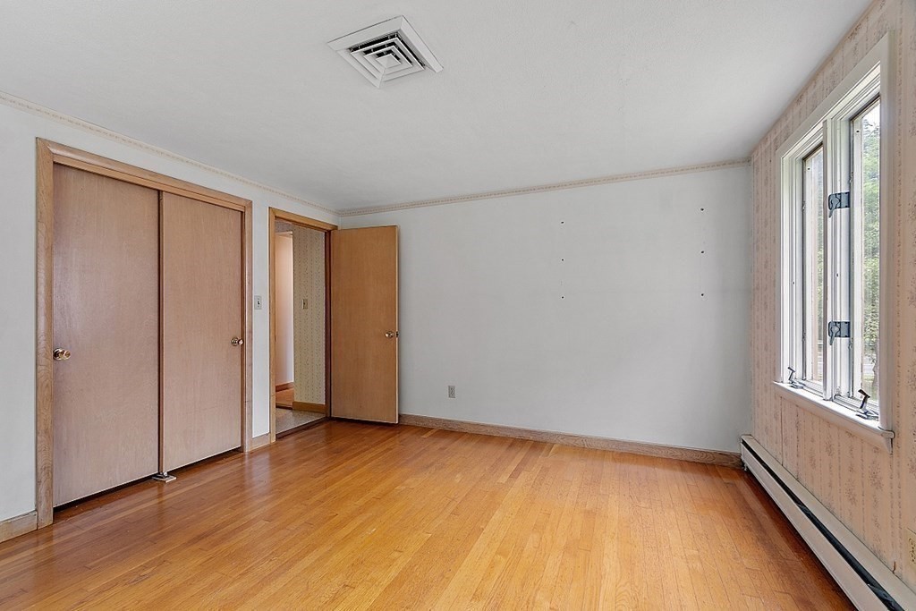 911 Main Street Reading, MA 01867 - Photo 17 of 42 an empty room with wooden floor and windows