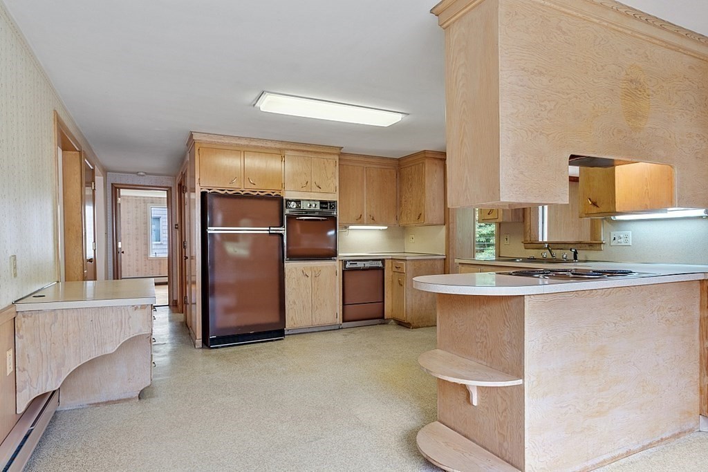 911 Main Street Reading, MA 01867 - Photo 23 of 42 a kitchen with stainless steel appliances granite countertop a sink stove and refrigerator