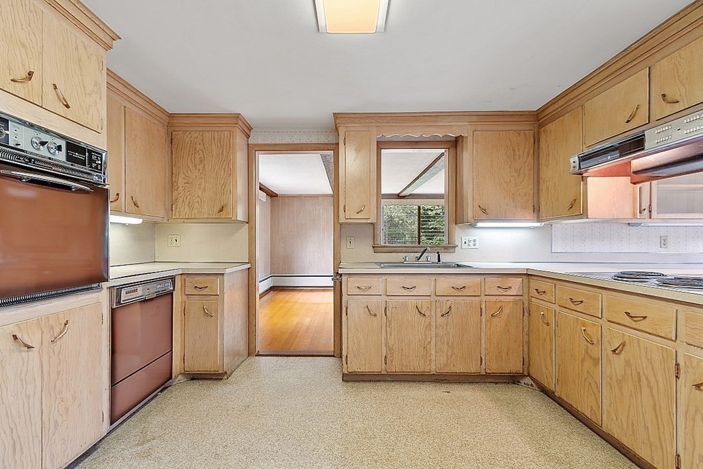 911 Main Street Reading, MA 01867 - Photo 24 of 42 a kitchen with granite countertop white cabinets white stainless steel appliances a sink and a window