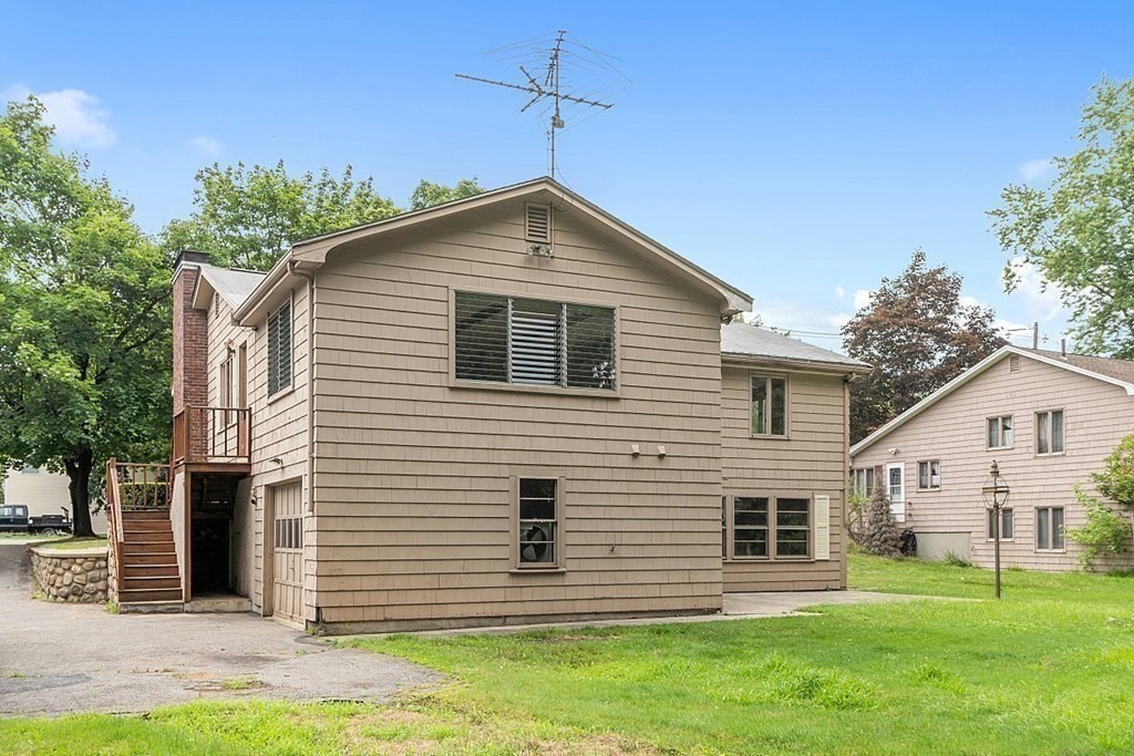 911 Main Street Reading, MA 01867 - Photo 37 of 42 a front view of a house with a yard
