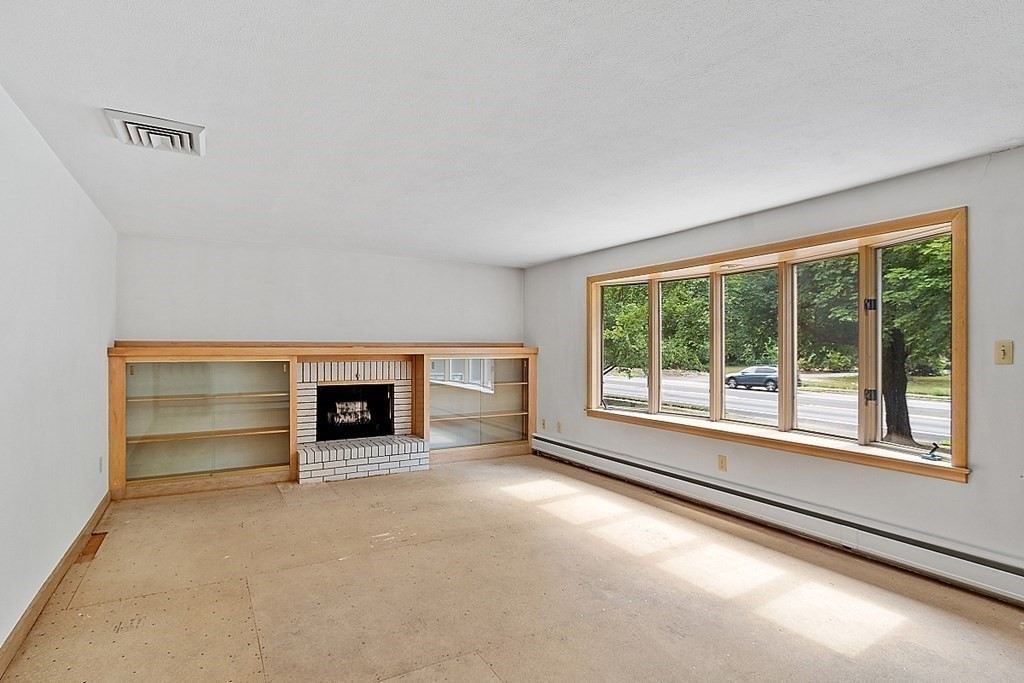 911 Main Street Reading, MA 01867 - Photo 8 of 42 a view of empty room with a fireplace and window