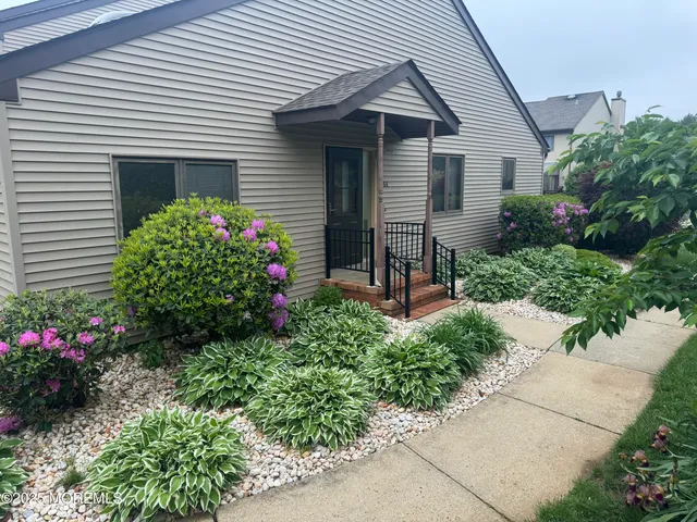 a front view of a house with a flower garden