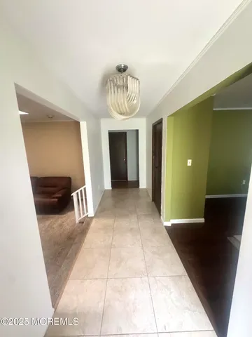 a view of a hallway with furniture and a chandelier
