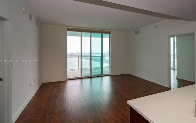 a view of a room with wooden floor and window
