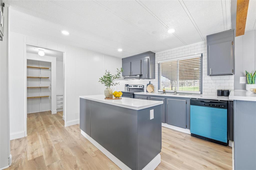 960 Pecan Street Azle, TX 76020 - Photo 11 of 34 a kitchen with stainless steel appliances a sink a stove a refrigerator cabinets and a window