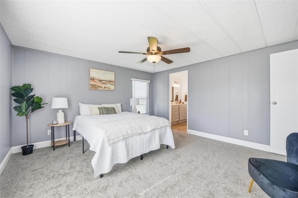 960 Pecan Street Azle, TX 76020 - Photo 19 of 34 a spacious bedroom with a bed and a chandelier