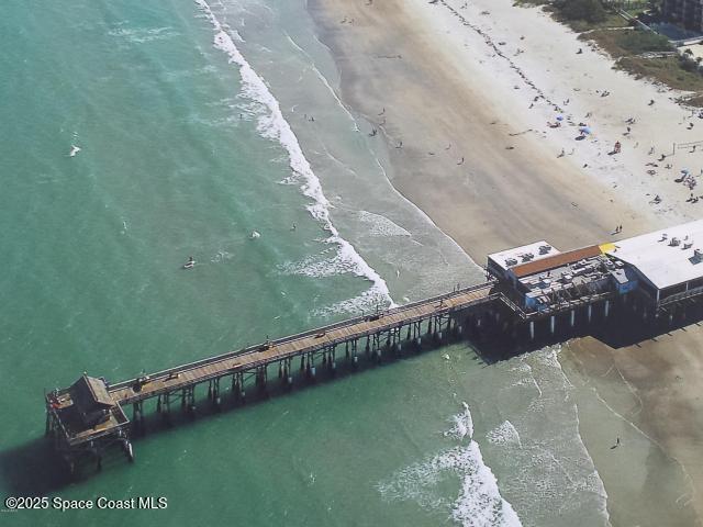 1830 North Atlantic Avenue, Unit C102 Cocoa Beach, FL 32931 - Photo 21 of 21 a wooden bench sitting in the middle of a beach