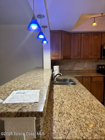 a kitchen with a stove a sink and a wooden cabinets