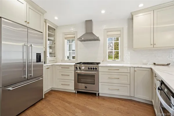 a kitchen with white cabinets and stainless steel appliances