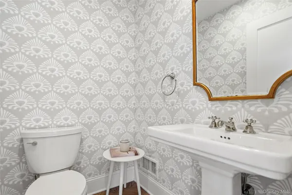 a bathroom with a toilet sink and mirror