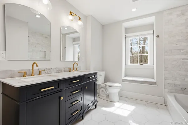 a bathroom with a double vanity sink a toilet and a mirror