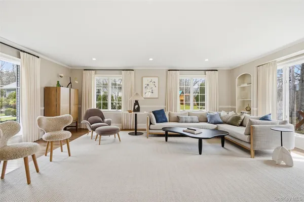 a living room with furniture and floor to ceiling windows