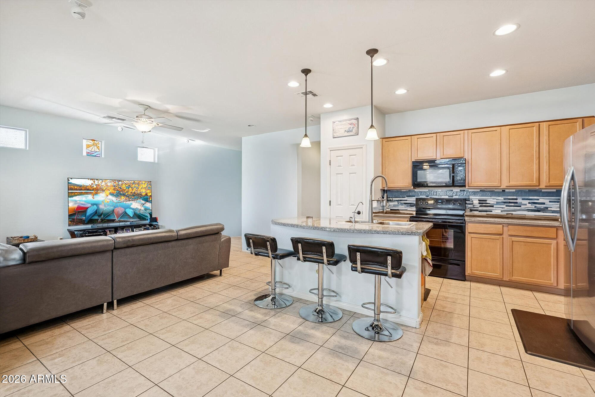 16632 South 175th Drive Goodyear, AZ 85338 - Photo 5 of 22 a kitchen with stainless steel appliances kitchen island granite countertop a sink and cabinets