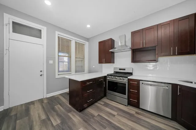 a kitchen with stainless steel appliances granite countertop wooden cabinets and a stove top oven