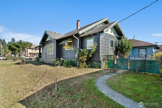 a front view of a house with a yard and potted plants