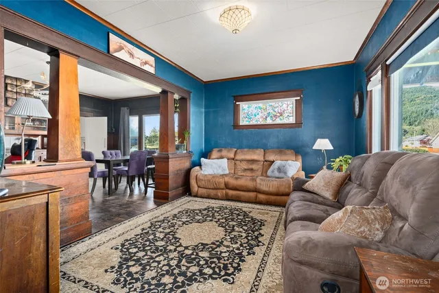a living room with furniture two window and a dining table