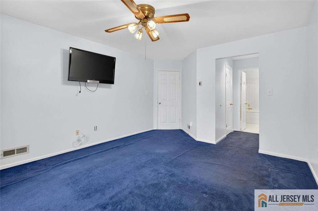 40C Rutland Lane, Unit 40B Monroe Township, NJ 08831 - Photo 20 of 37 an empty room with windows flat screen tv and fan
