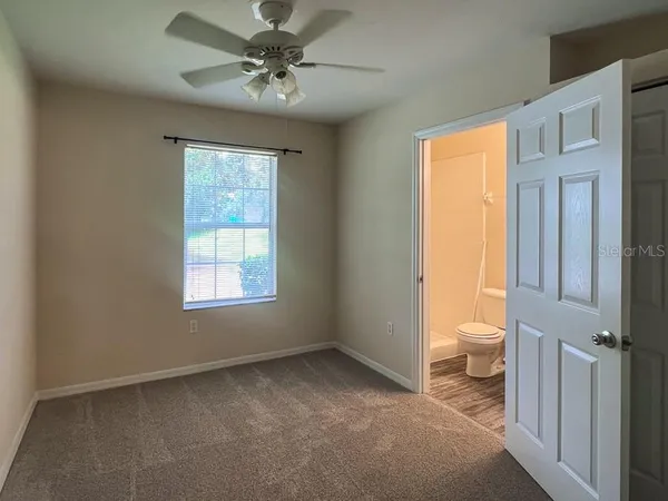 a view of a room with a ceiling fan and a bathroom view
