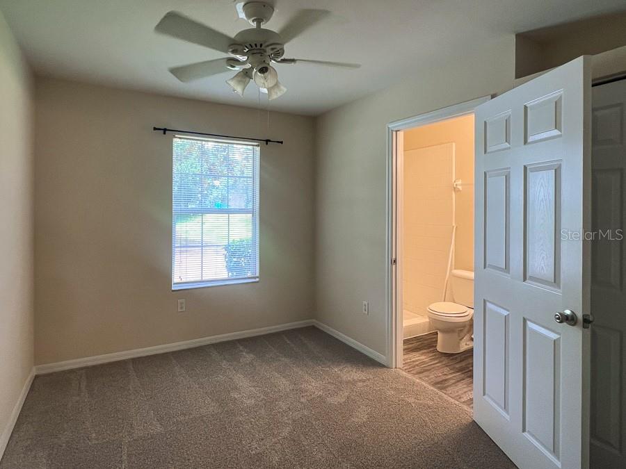 3911 Southwest 27th Street, Unit 9 Gainesville, FL 32608 - Photo 12 of 16 a view of a room with a ceiling fan and a bathroom view