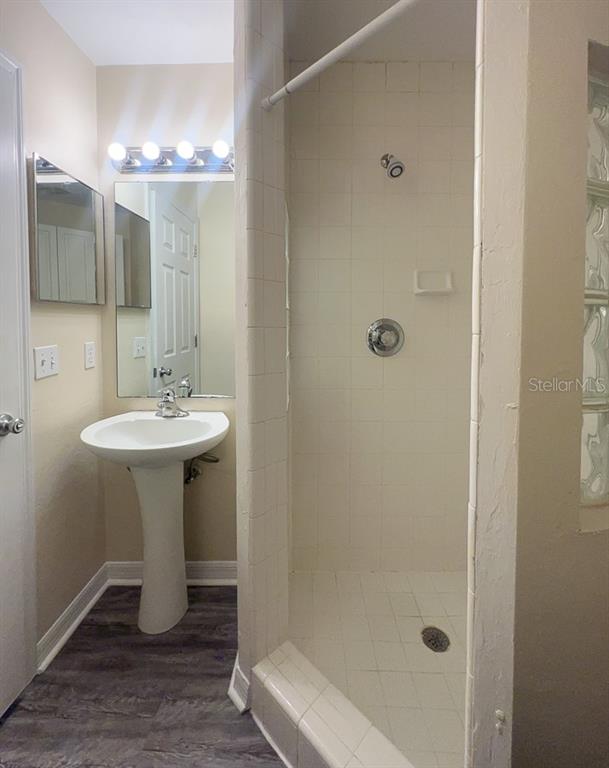 3911 Southwest 27th Street, Unit 9 Gainesville, FL 32608 - Photo 3 of 16 a bathroom with a sink a mirror and a shower