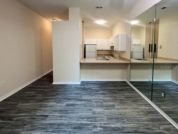 a view of a kitchen with kitchen island a sink stainless steel appliances and cabinets