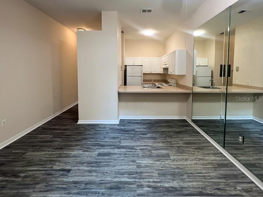 3911 Southwest 27th Street, Unit 9 Gainesville, FL 32608 - Photo 5 of 16 a view of a kitchen with kitchen island a sink stainless steel appliances and cabinets