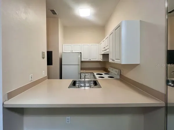 a kitchen with a refrigerator and a stove