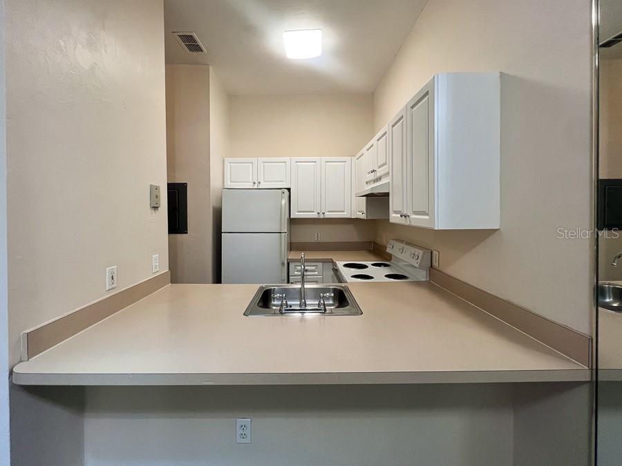 3911 Southwest 27th Street, Unit 9 Gainesville, FL 32608 - Photo 7 of 16 a kitchen with a refrigerator and a stove