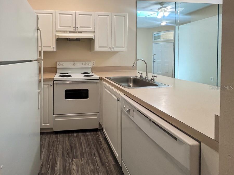 3911 Southwest 27th Street, Unit 9 Gainesville, FL 32608 - Photo 9 of 16 a kitchen with a white cabinets and white appliances