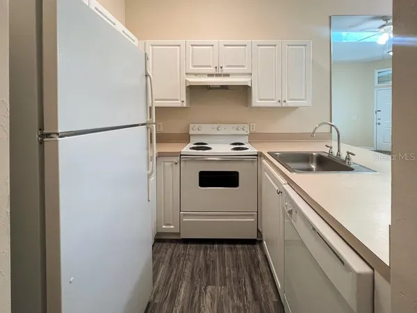 a kitchen with a white stove top oven and refrigerator
